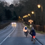 Usagers circulant à vélo sous un éclairage public vétuste